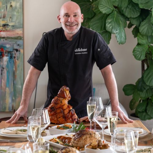 Chef Sebastien in front of the delidoor christmas menu including the glazed ham